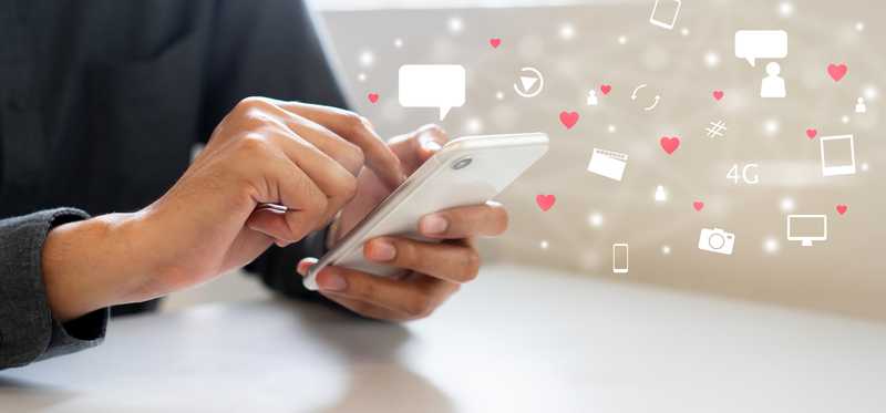 Person holding smartphone with icons floating in air
