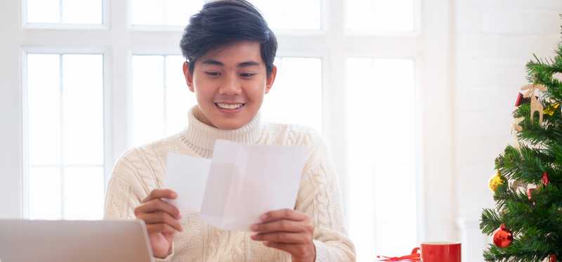 Smiling person reading holiday letter.