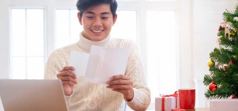 Smiling man reading holiday letter