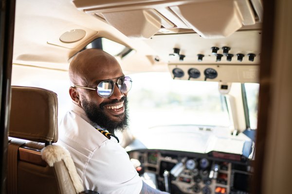smiling pilot in a cockpit.