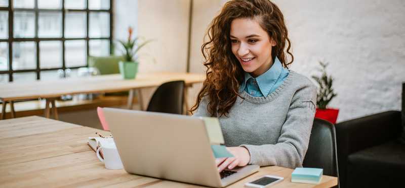 Smiling person at laptop.