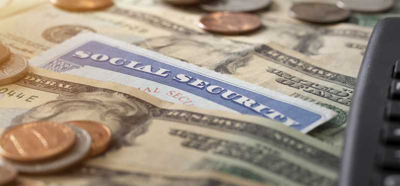 Social Security card with dollar bills and coins.