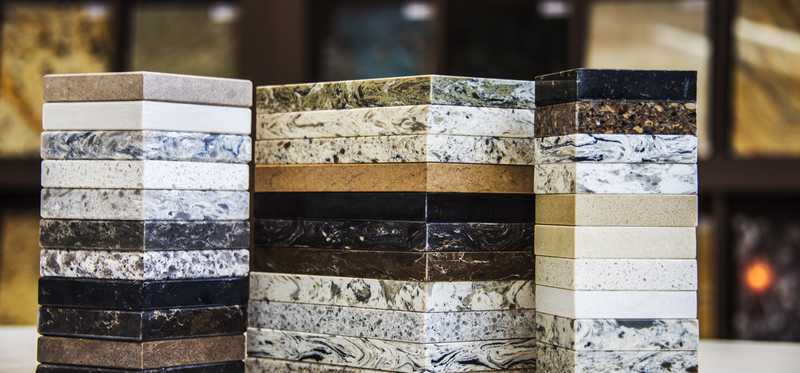 stacks of kitchen counter top samples in granite, marble, and quartz