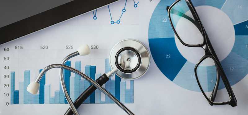 Stethoscope on table next to glasses and tablet