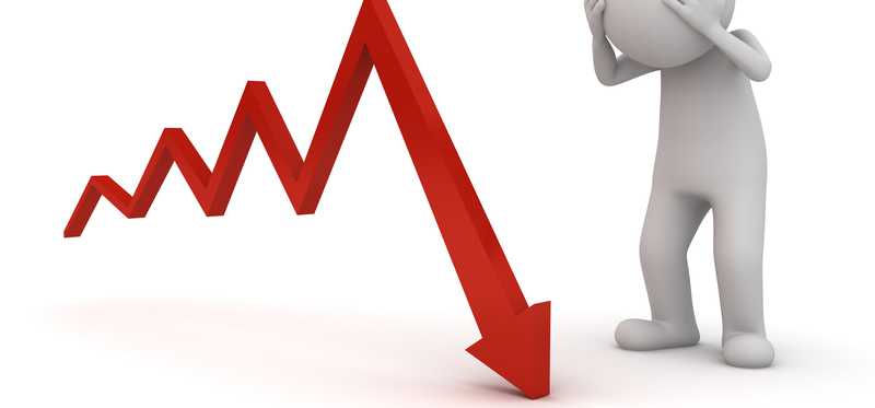 An illustrated figure holds its head as a stock arrow crashes.