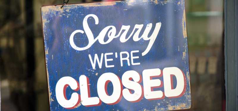 A sign on a door says Sorry We're Closed.