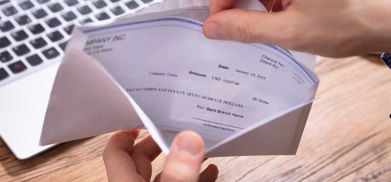 Person pulling a check from an envelope