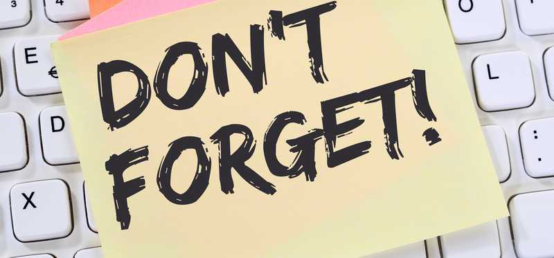 Post-it note reading Don't Forget stuck on keyboard