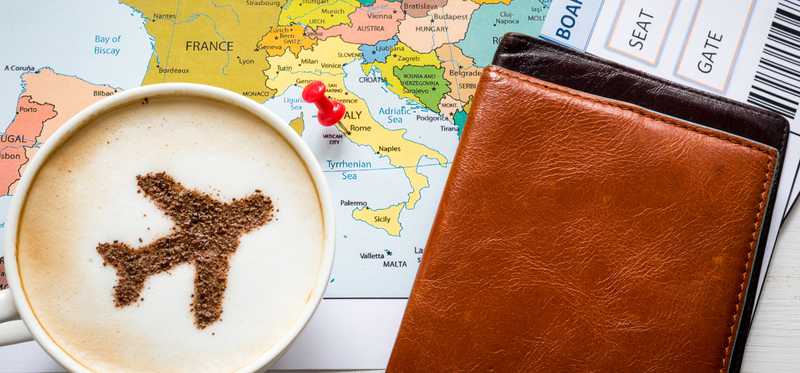 A plane is drawn on the foam of a cup of coffee sitting on a map