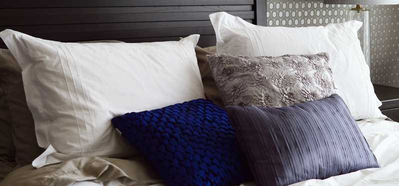 A guest bed made up with blankets and pillows.