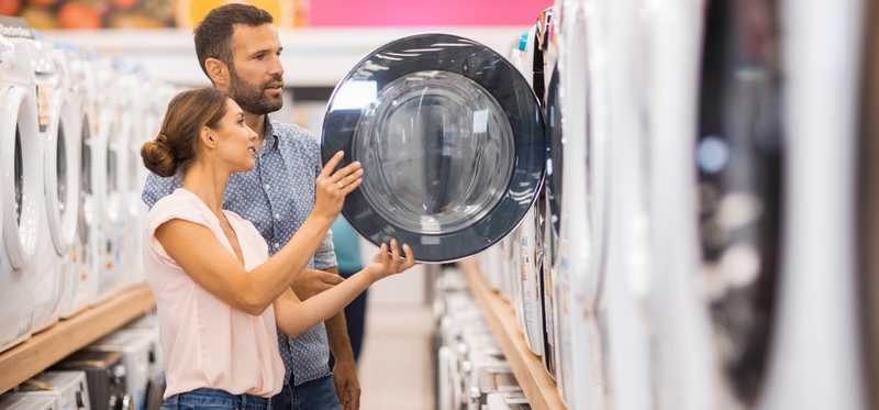 Two people shopping for a washing machine.