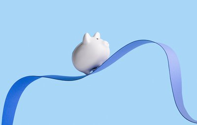 white piggy bank riding up and down on a ribbon
