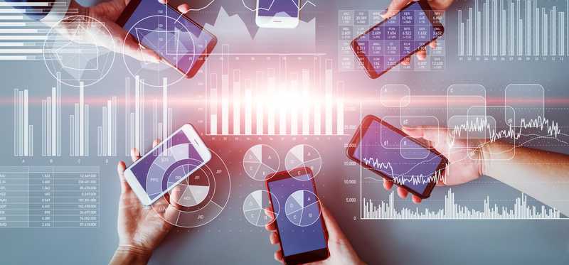 Roundtable of people holding their mobile devices connected by wireless network