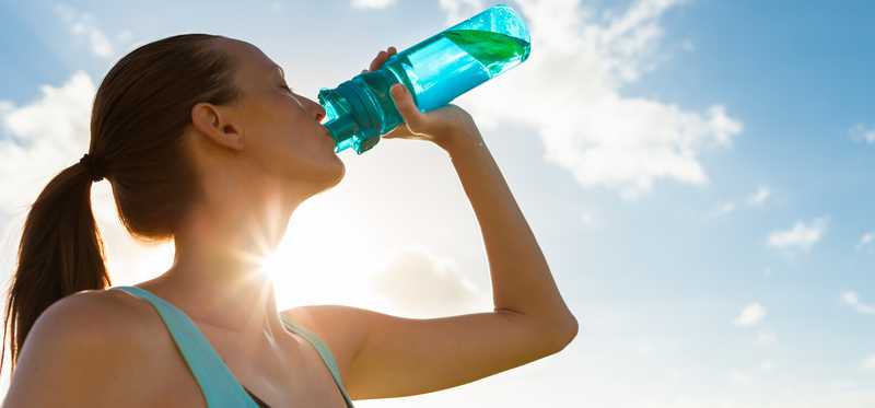 Person drinking from plastic bottle.