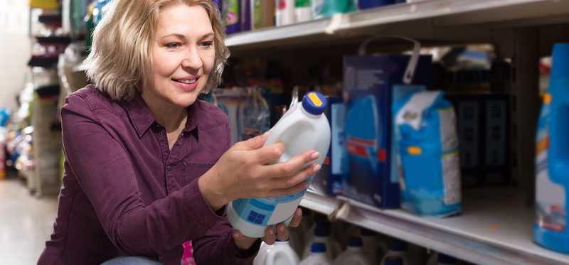 Woman shopping and holding bleach bottle