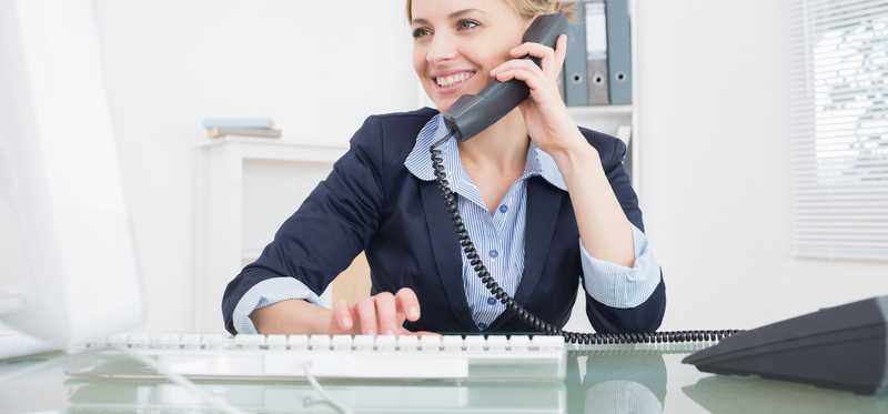 Woman at desk talking on the phone.
