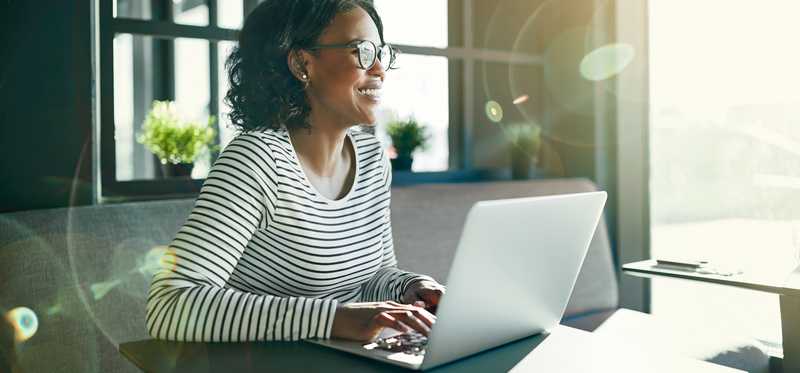 Woman using her laptop from a home desk.