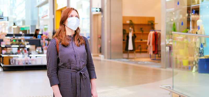 Woman in face mask standing in mall