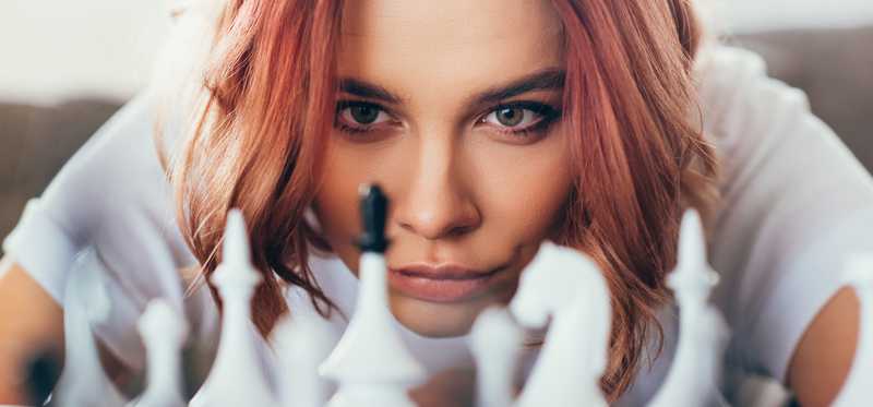 Person playing chess and contemplating next move.
