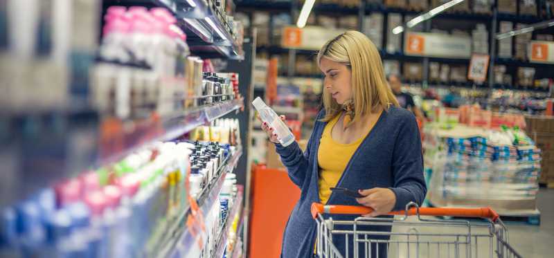 Person shopping in warehouse store with cart.