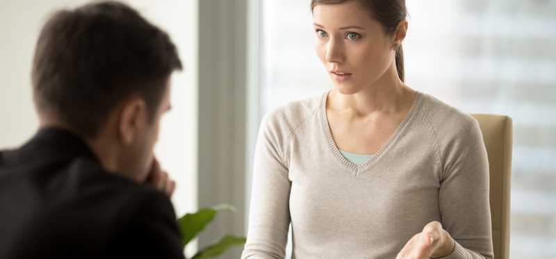 Woman showing a man a document.