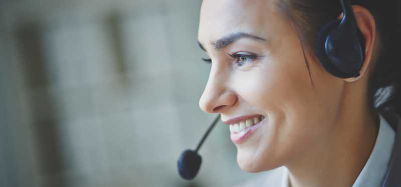 Woman wearing a headset and smiling.