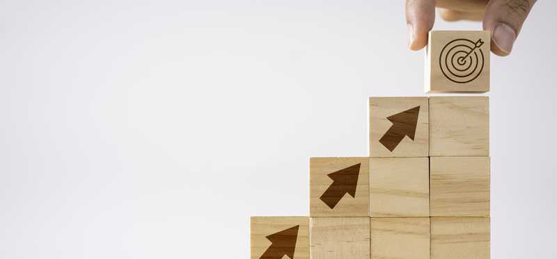 Wood blocks with arrows in rising stack top block imprinted with bulls-eye