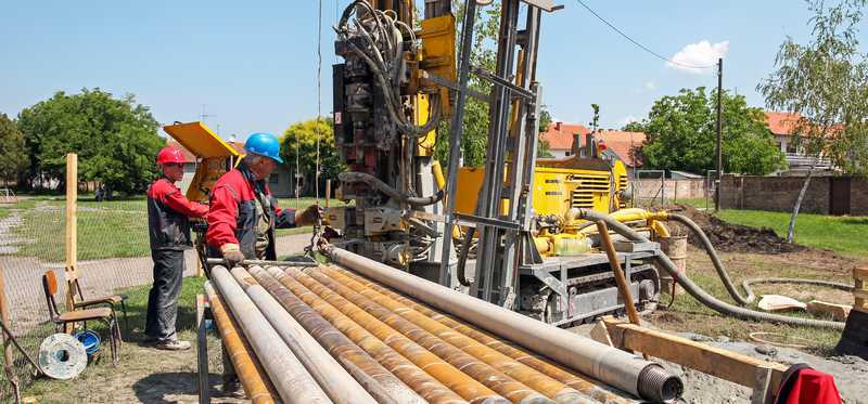 Workers in hardhats on a drilling rig.