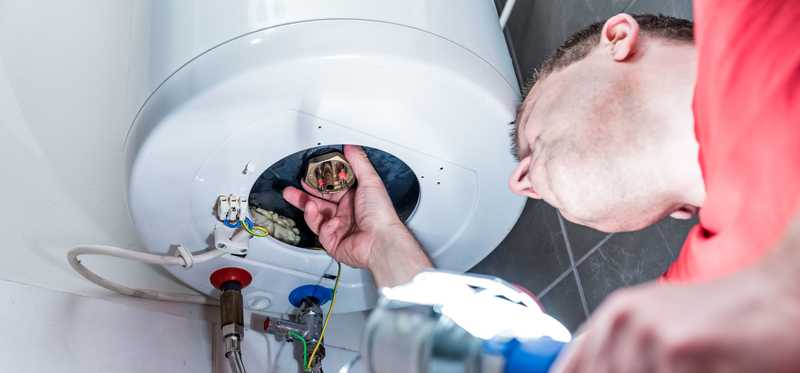 Person working on a water heater.