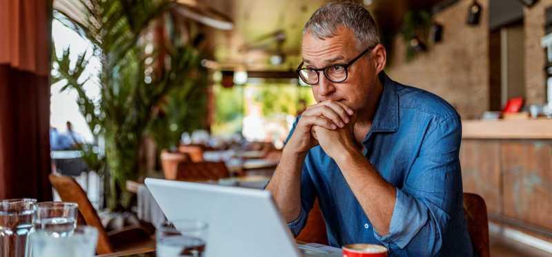 Person with serious expression at laptop.