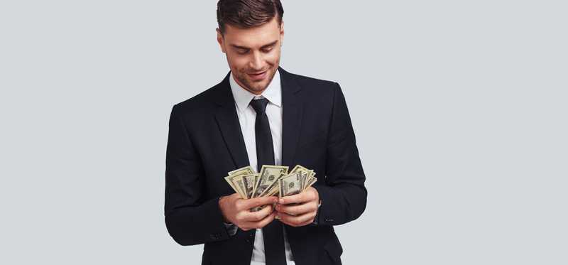 Young male in suit counting bills.