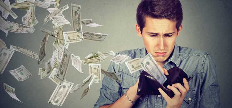 Person looking sad as money flies out of a wallet.