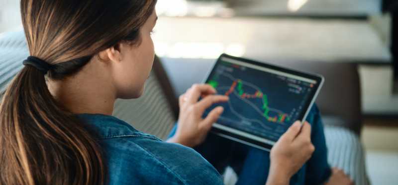 Person using a tablet to look at the performance of stocks.