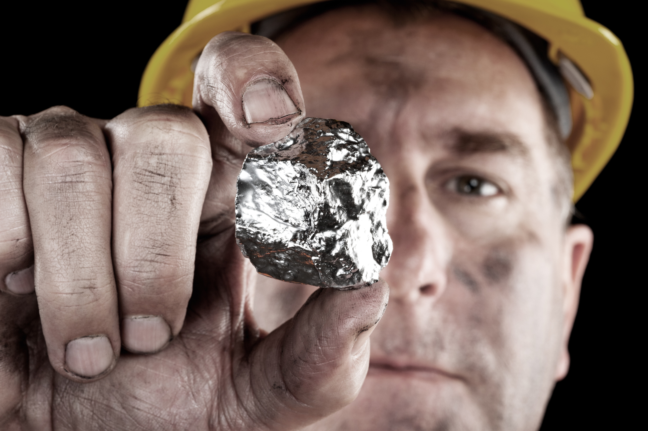 Miner holding up a silver nugget. Miner holding up a silver nugget.