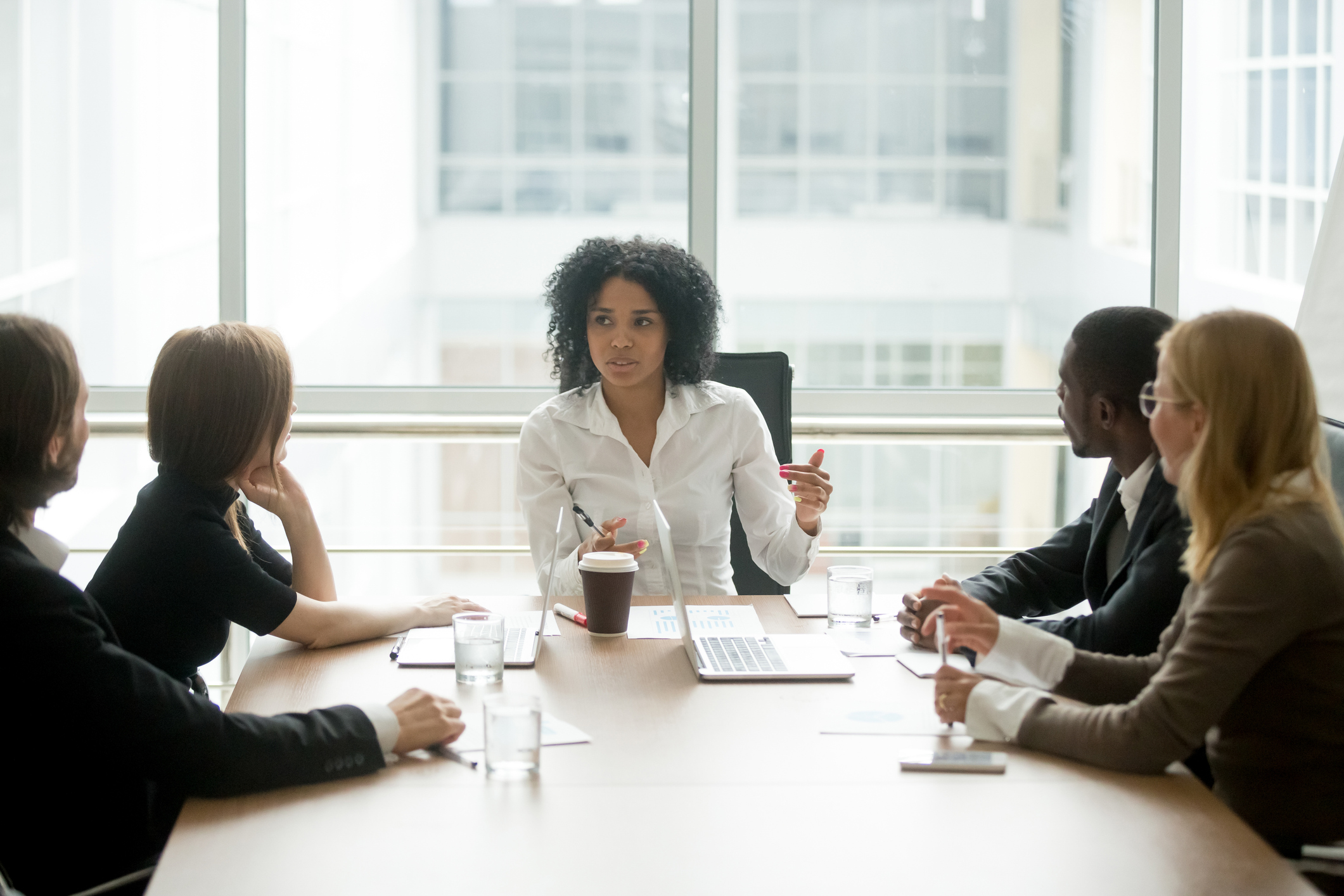 A businessperson at the head of a table leading a meeting. A businessperson at the head of a table leading a meeting.