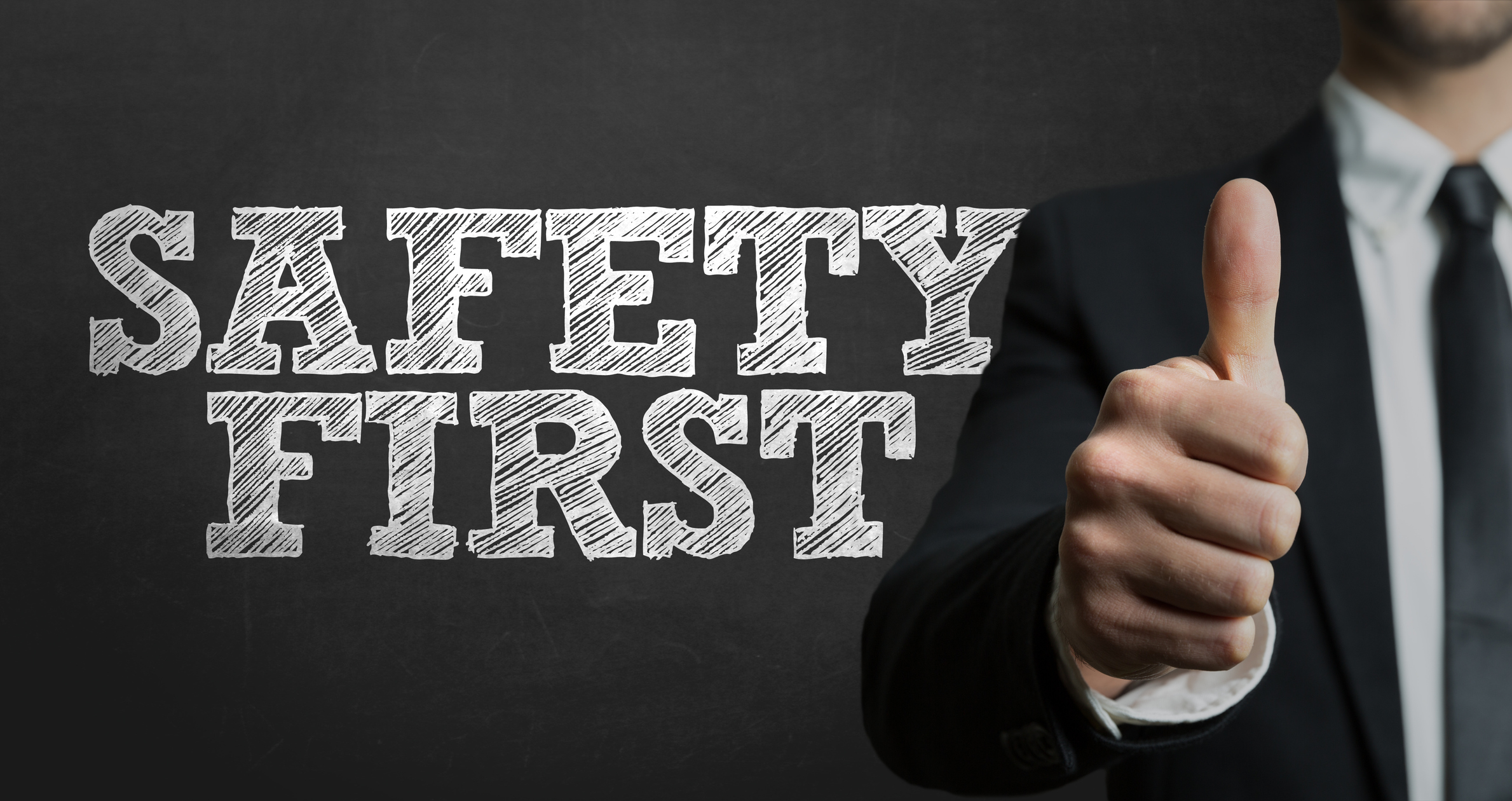 the words safety first with a man giving a thumbs up sign in the background The words Safety First with a person giving a thumbs up sign in the background.