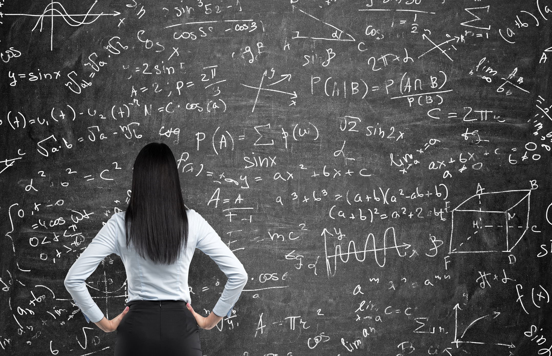 Person looking at confusing formulas Person with hands on hips and looking at a blackboard full of math formulas.