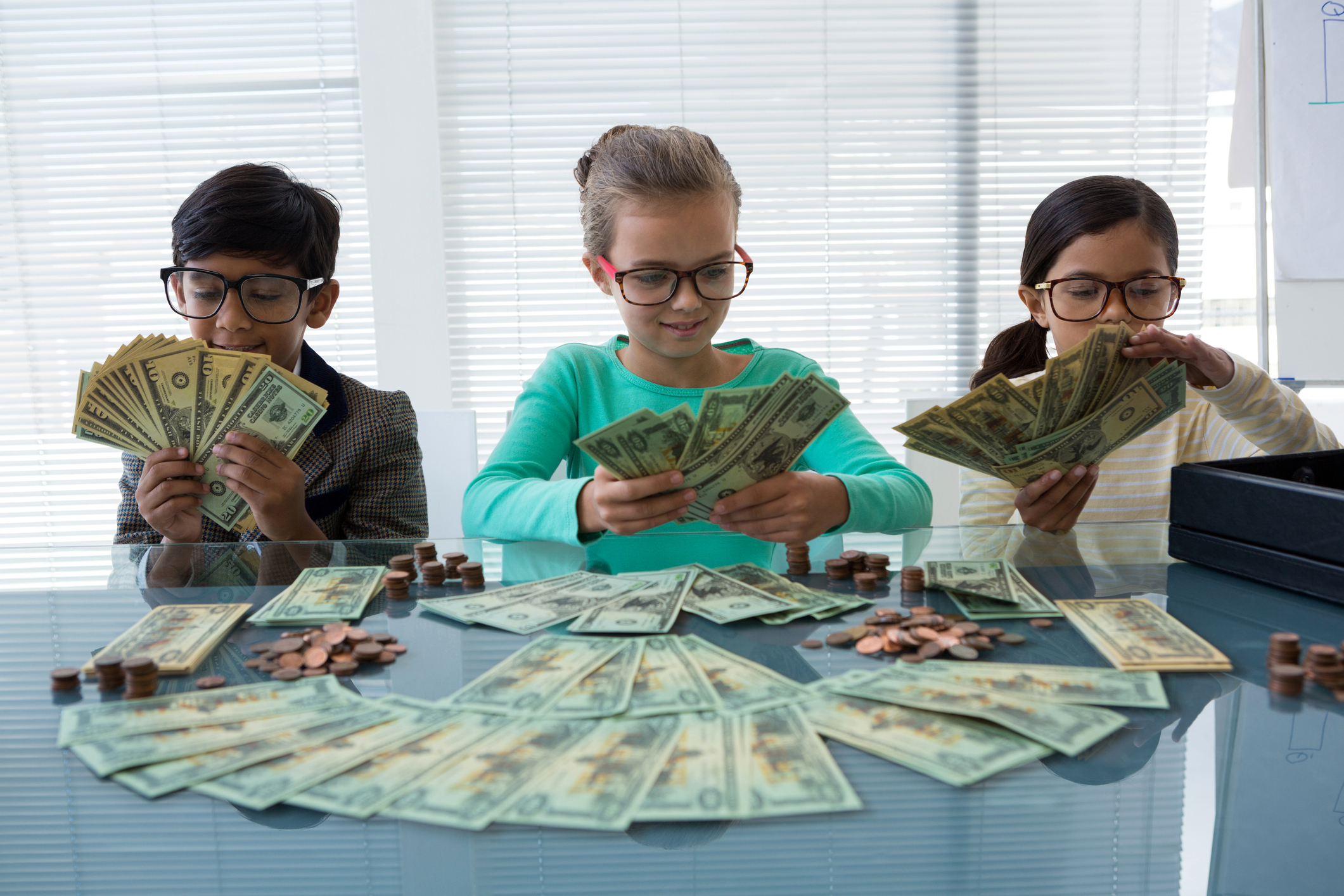 Three young kids with piles of money.
