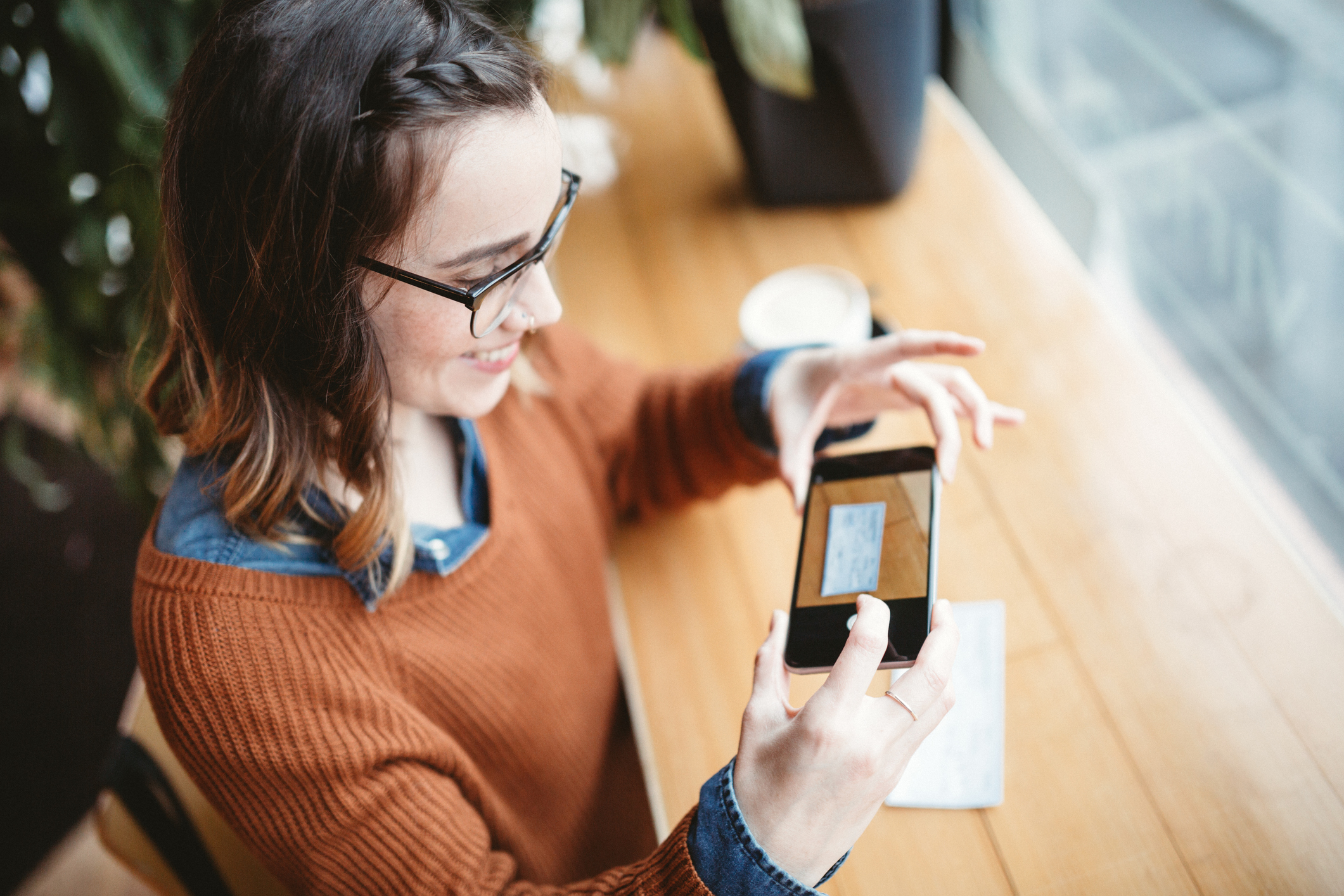 woman uses smartphone to deposit paycheck. Adult smiles while using smartphone to deposit a paycheck.
