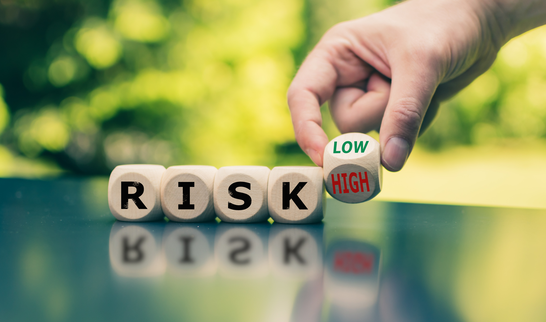 Blocks spelling out the word RISK with the final block being turned from Low to High. Blocks spelling out the word Risk with the final block being turned from Low to High.