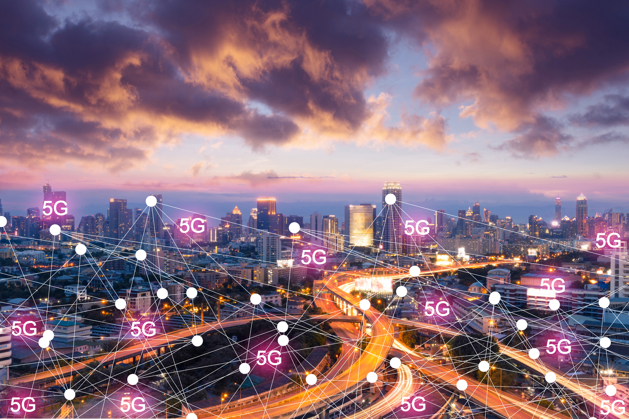 5g.jpg View overlooking a large city that is lit up with a network of 5G ping points