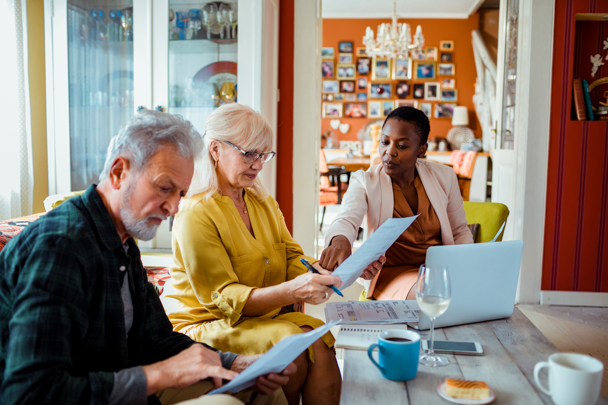 Couple signing paperwork with financial advisor.