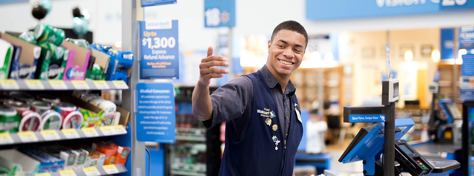 Smiling Walmart cashier signaling for next customer