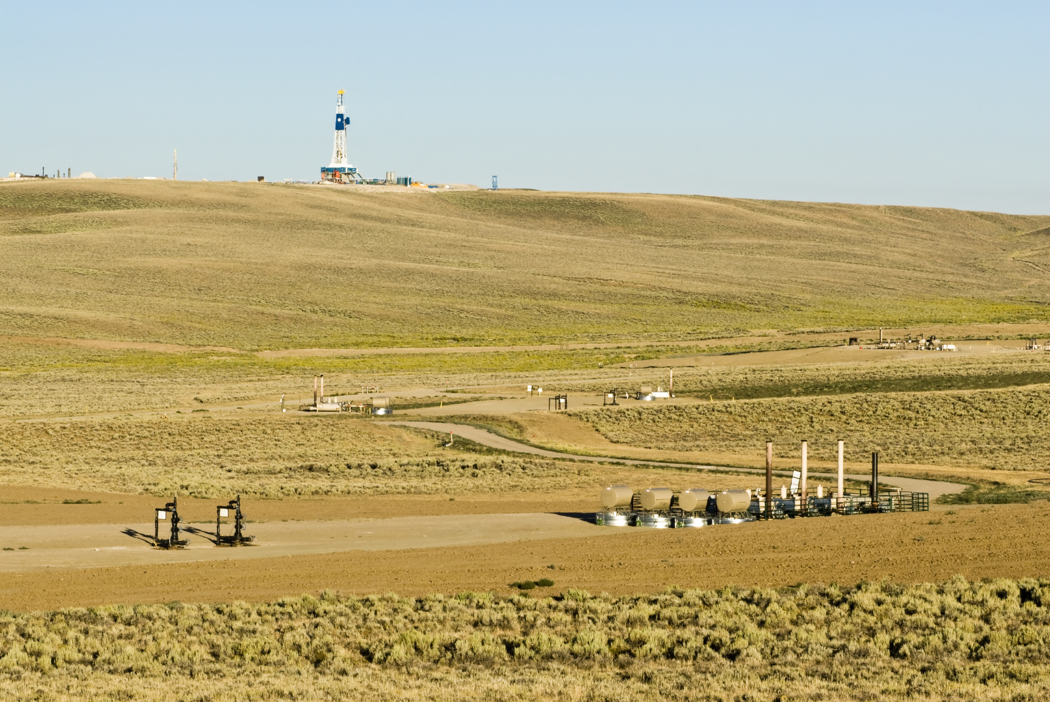 A natural gas field with a drilling rig.
