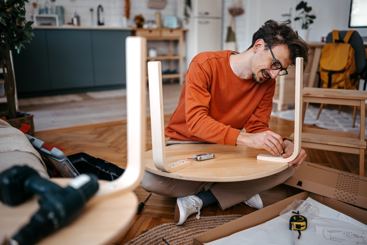 A person building furniture. A person building furniture.