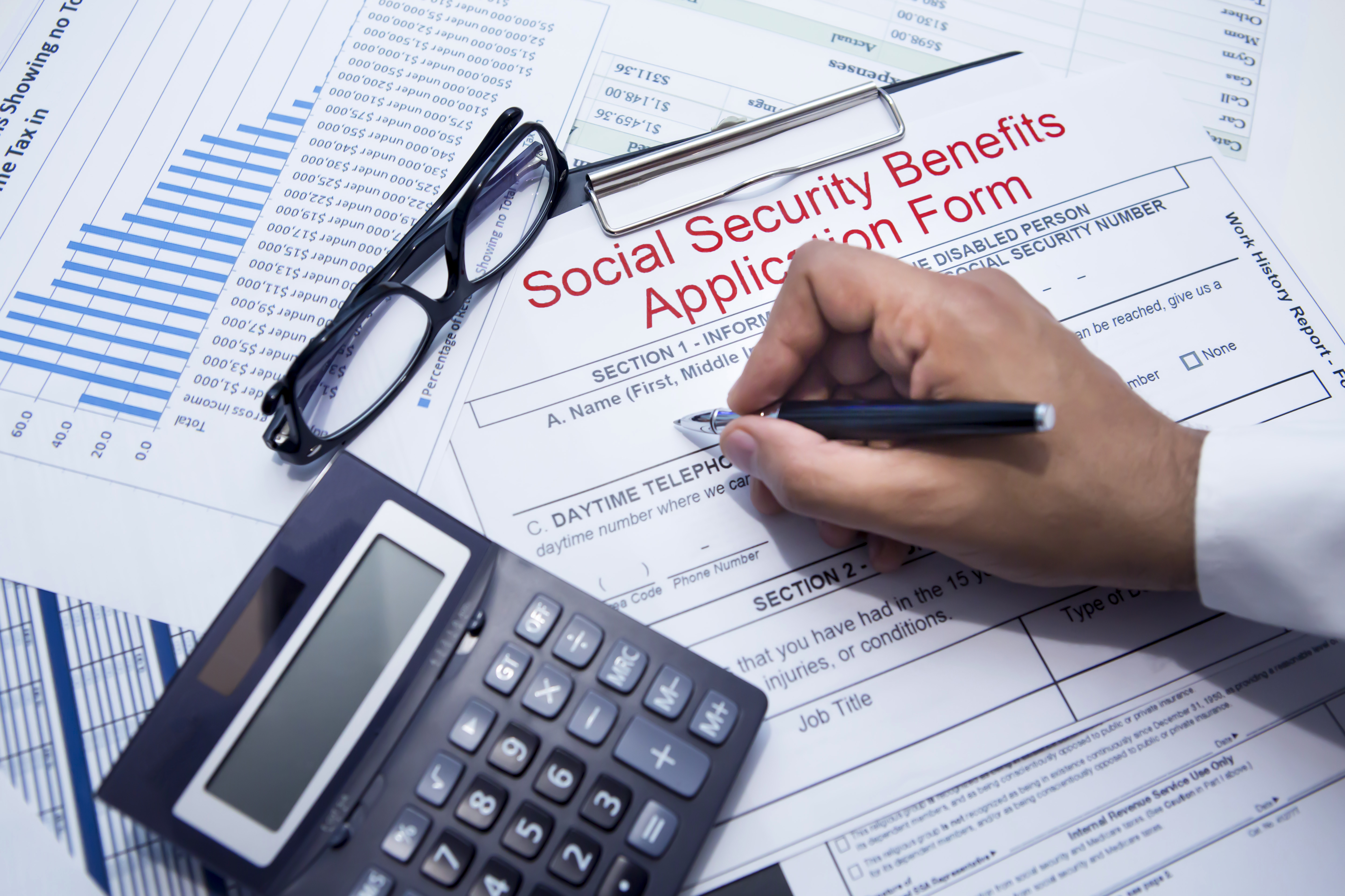 A person filing out a Social Security benefits application form.