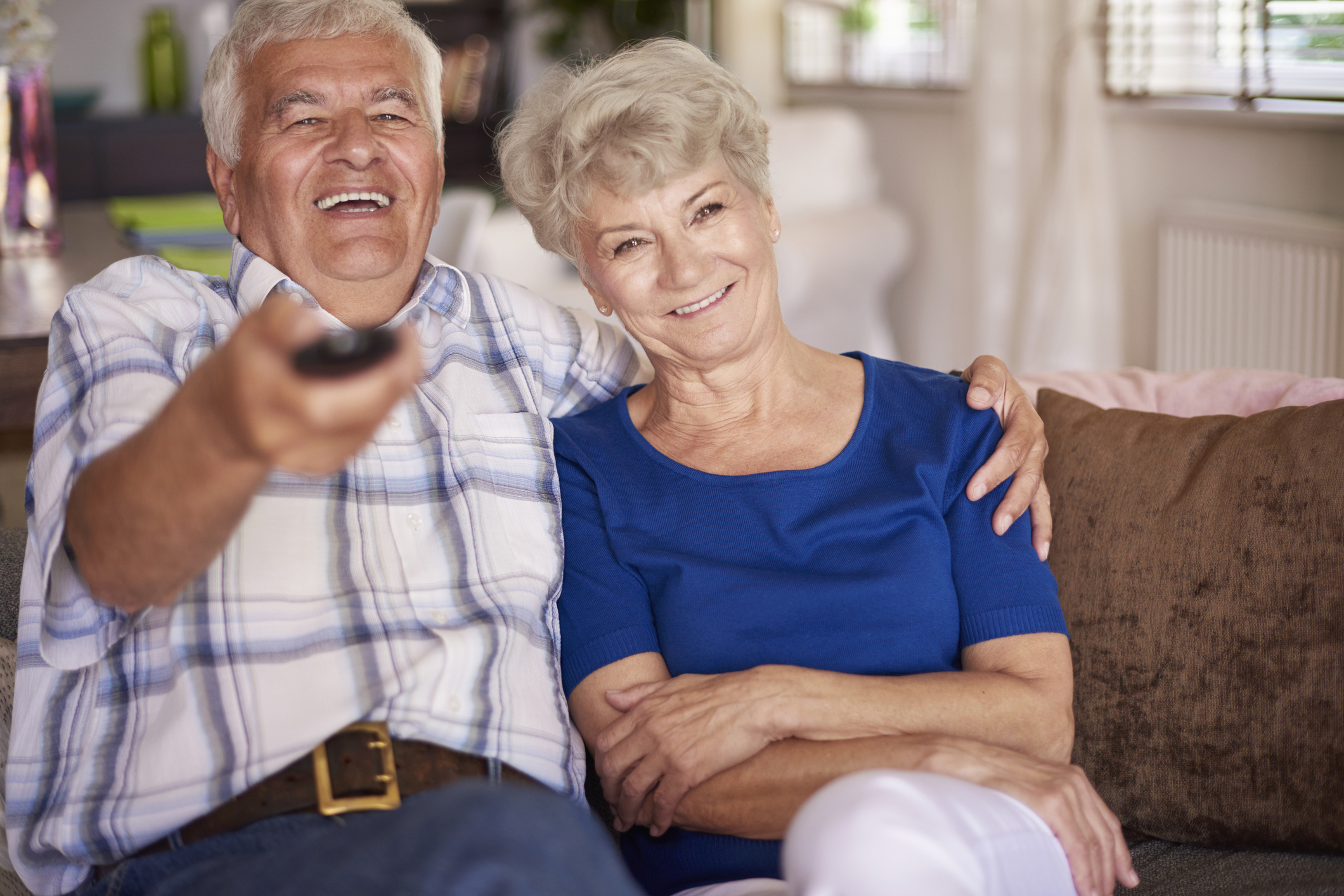 Couple watching television together. A couple sitting on a couch and watching television together.