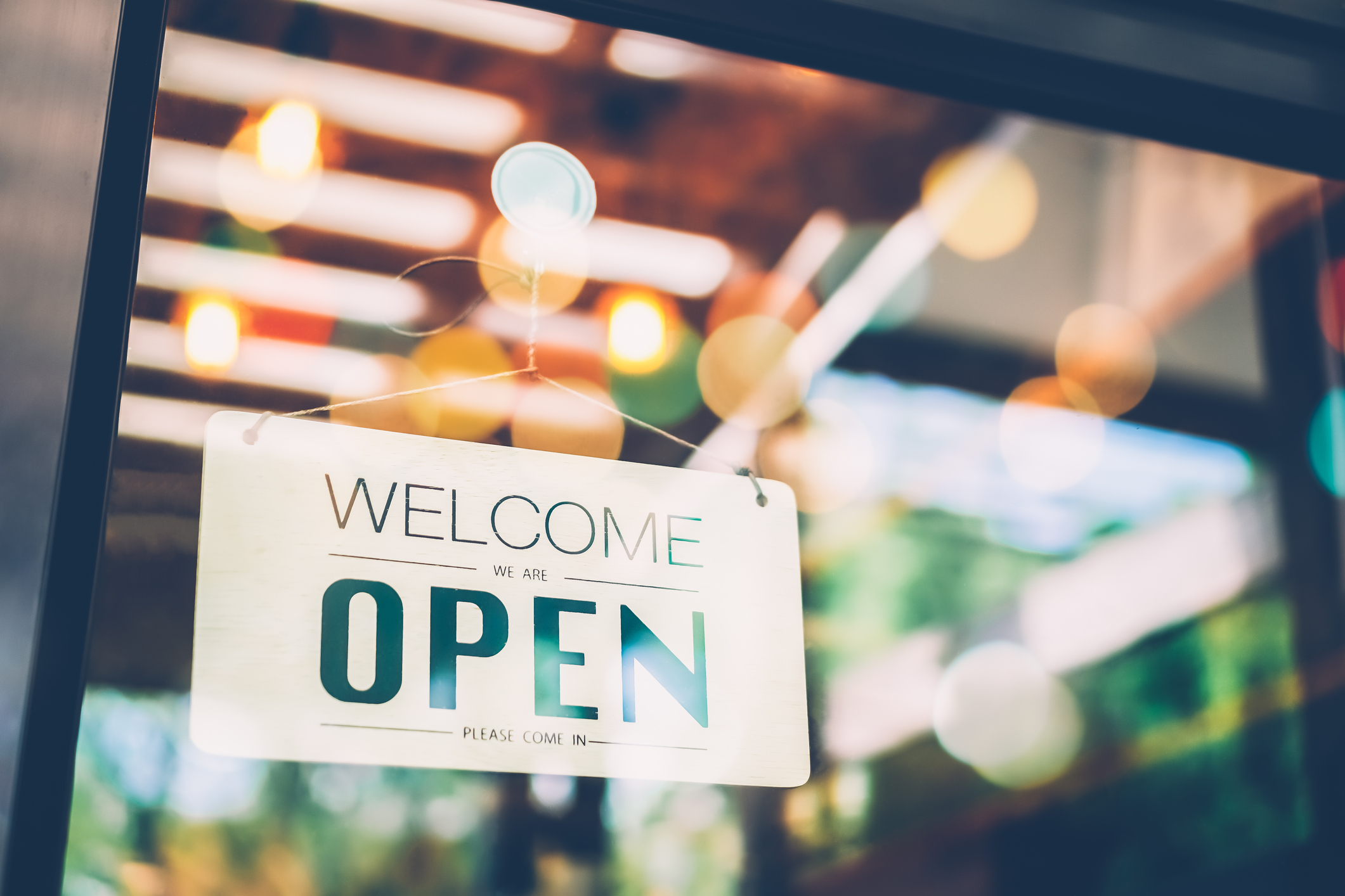 Welcome We Are Open sign in the window of a start-up business.