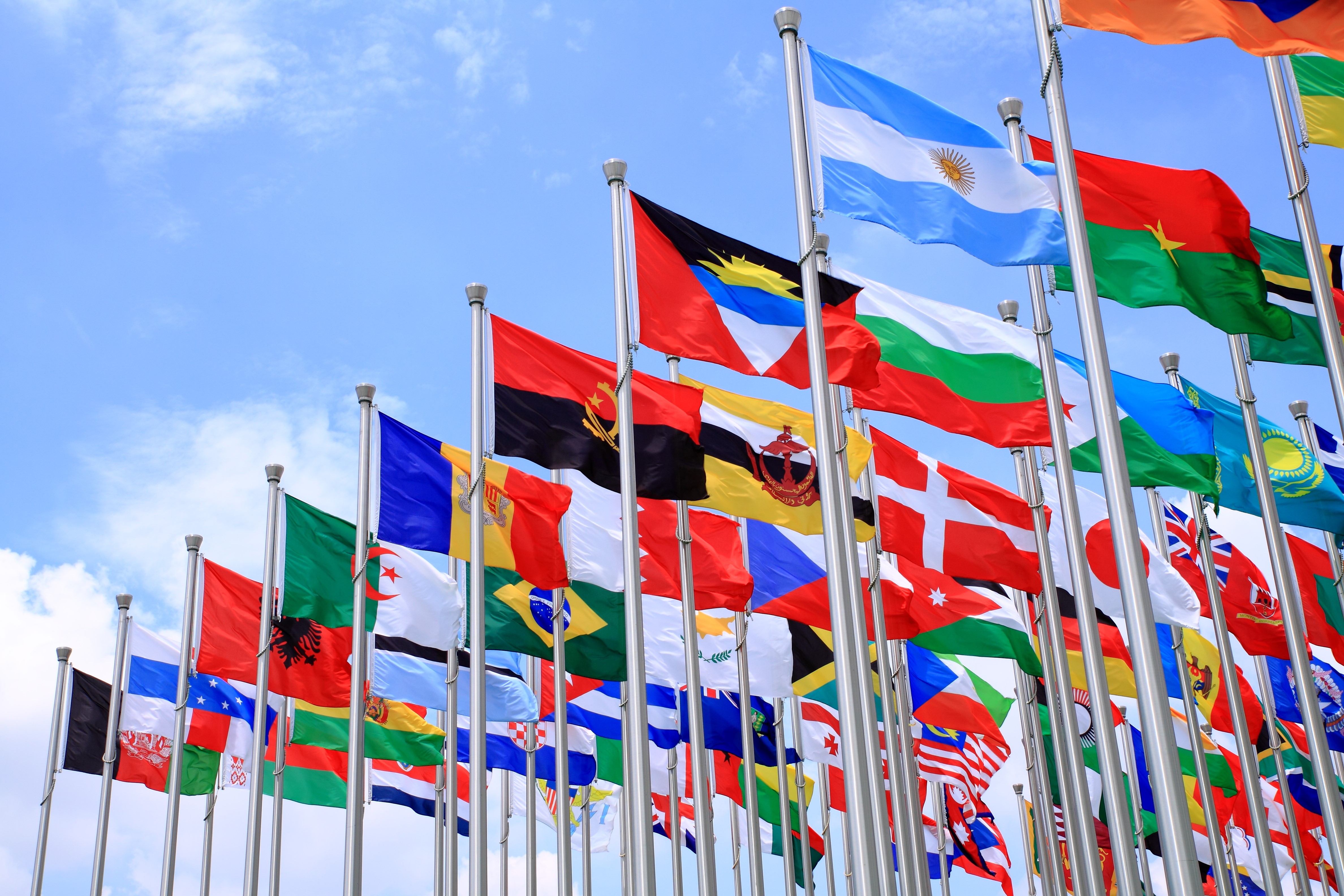 Lots of flagpoles flying flags of different countries.