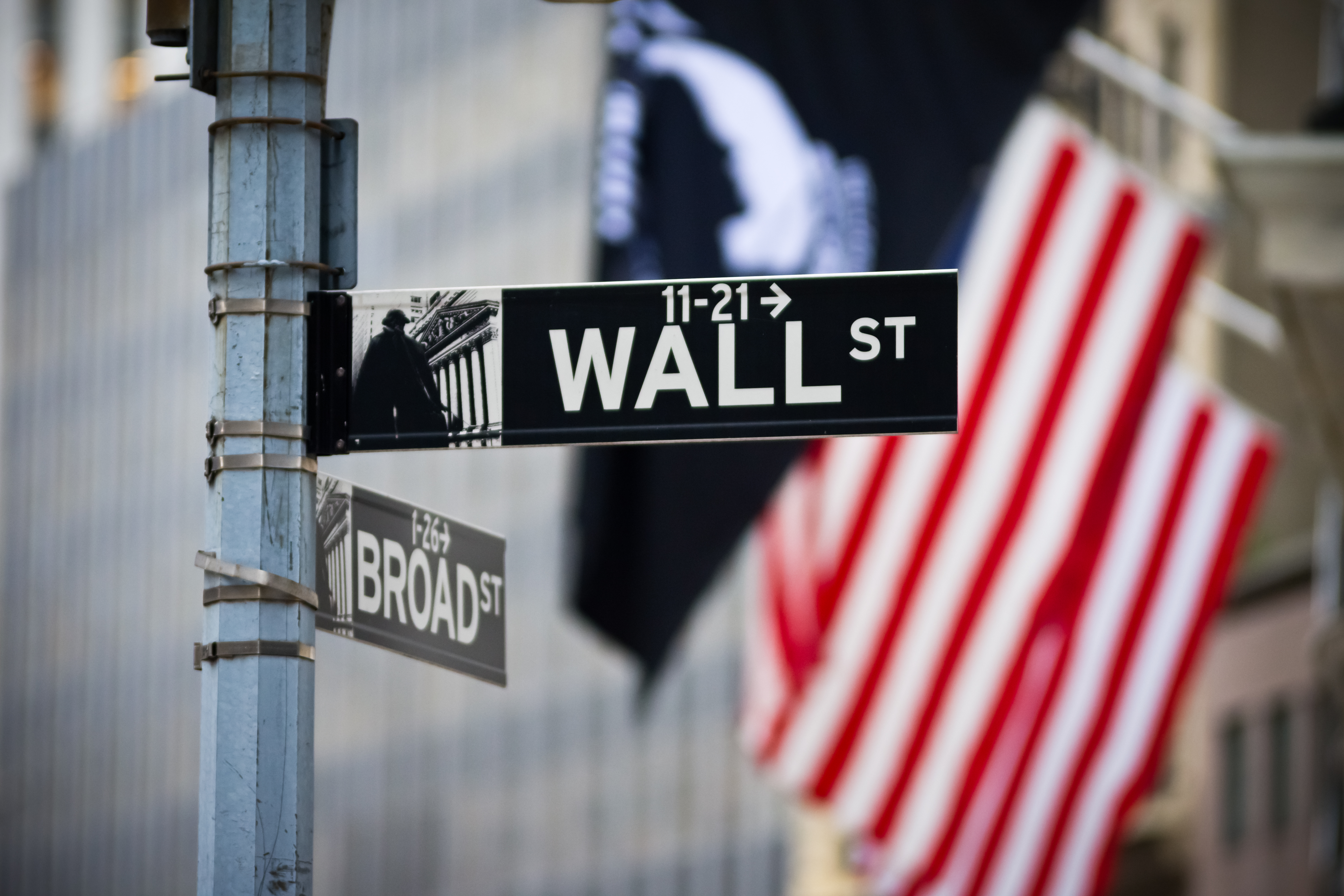 Wall Street Photo of the Wall Street street sign with American flag in the background.